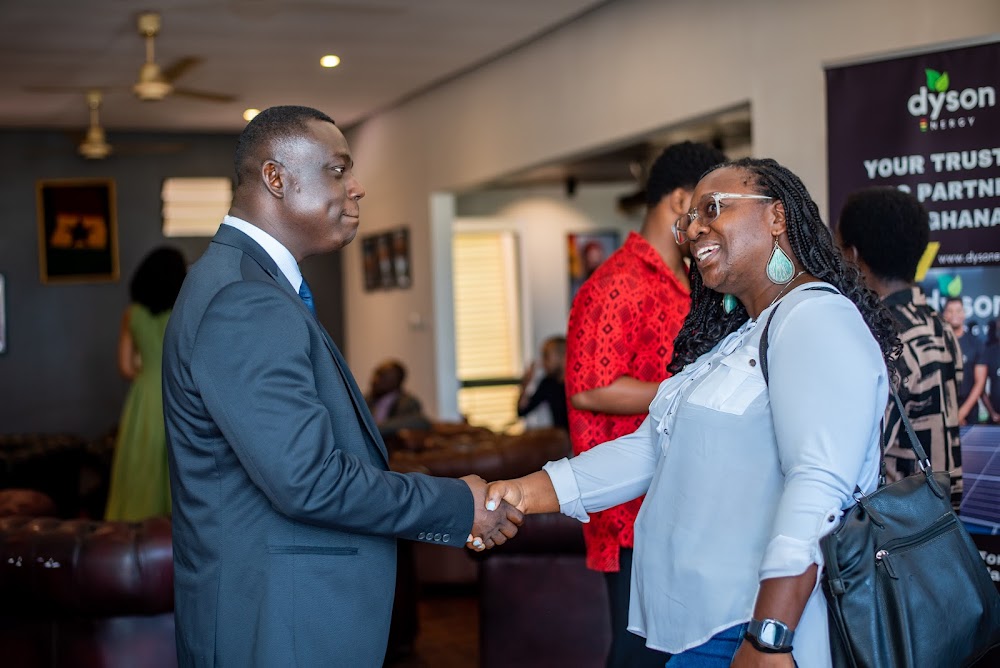 A guest and a business partner shaking hands at a Friends of Ireland Ghana event.