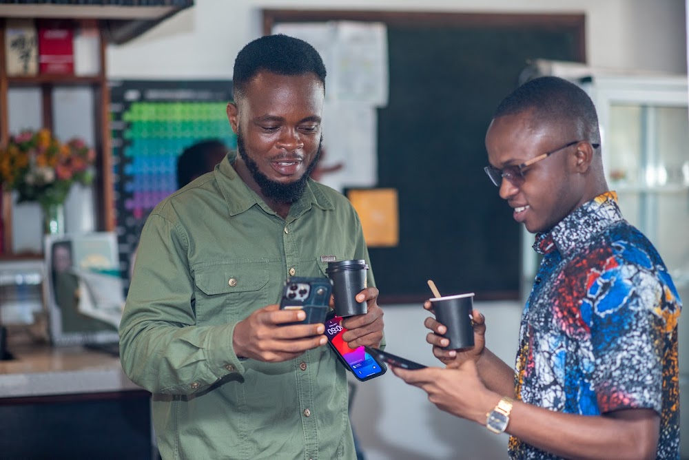Two young attendees comparing notes at a Friends of Ireland Ghana event.