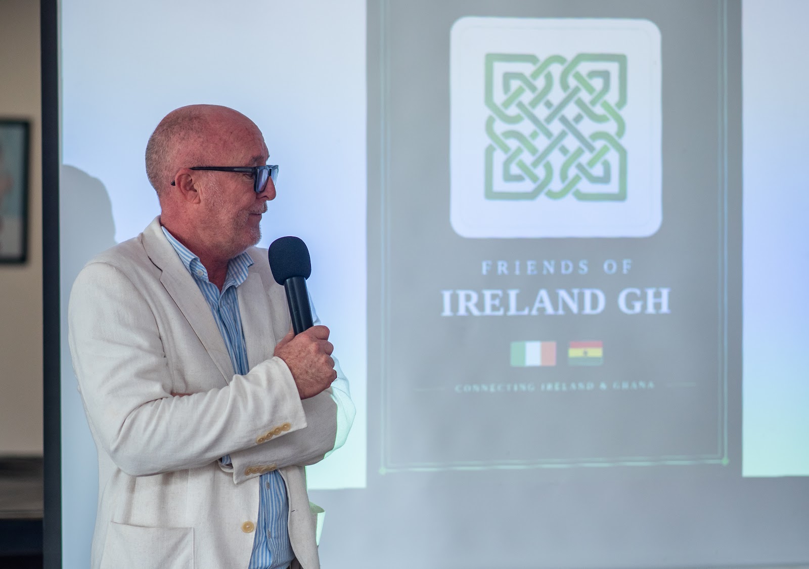 A speaker sharing an update at a Friends of Ireland Ghana gathering.